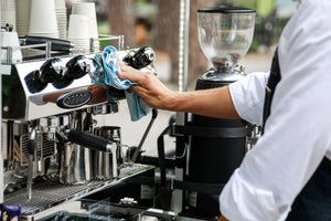 Barista cleans espresso machine