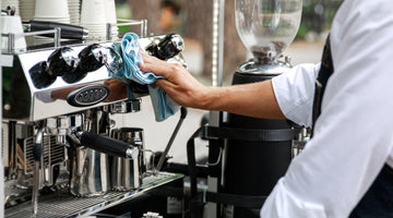 Barista cleans espresso machine