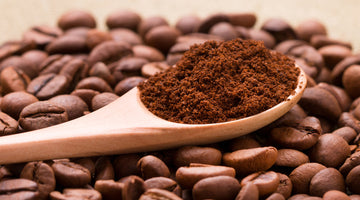 Coffee blend ground on spoon resting on pile of coffee beans