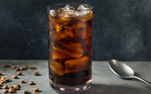 Cup of cold brew coffee on table