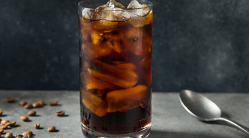 Cup of cold brew coffee on table