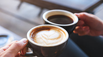 Hands holding two espresso drinks